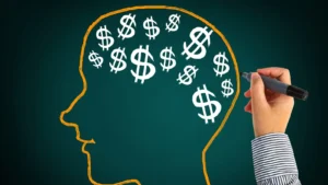 Uma pessoa desenhando uma pessoa com vários cifrões de dinheiro dentro de sua cabeça
