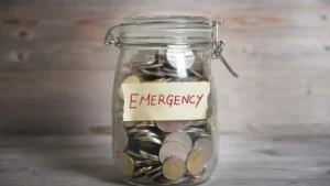 Pote com etiqueta escrito "emergência" com dinheiro em moedas dentro