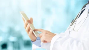 Uma médica seguran e mexendo em seu telefone